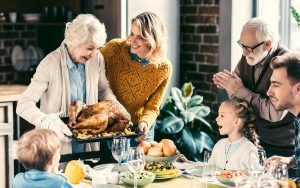 Family enjoying Thanksgiving dinner while wearing hearing aids.